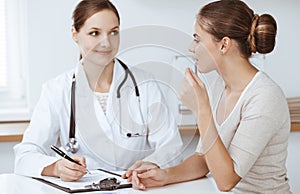 Doctor and patient are sitting and discussing health examination results in clinic office. Health care, medicine and