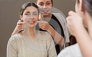 Doctor and patient sitting in front of a mirror, working on diction