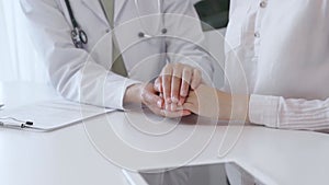 Doctor and patient sitting at the white table in the hospital. The pediatrician in a green blouse and white medical coat