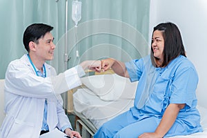 Doctor and patient are use hands fist bump to show encouragement