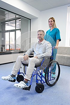Doctor and patient in wheelchair looking at camera
