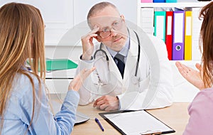 Doctor and patients discussing something in medical office . Medicine and health care concept. Doctor and patient