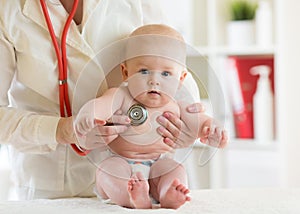 Doctor pediatric examining little child in clinic. Baby health concept