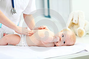 Doctor pediatrician examines baby tummy