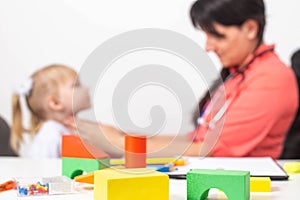 Doctor pediatrician examines the throat of a little girl. Copy space for text