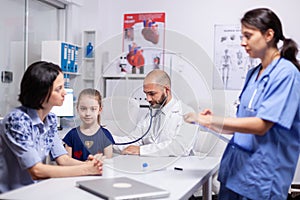 Doctor pediatry checking evolution of flu using stethoscope