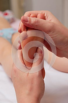 Doctor performing pediatric foot massage to prevent development of flat feet