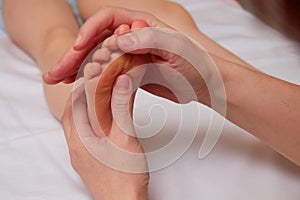 Doctor performing pediatric foot massage to prevent development of flat feet