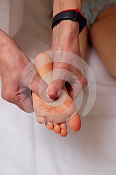 Doctor performing pediatric foot massage to prevent development of flat feet