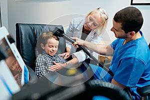 Paediatrician Doctor Doing Brain Treatment To Autistic Child In Clinic photo