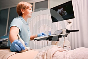 Doctor performing ultrasound procedure in modern clinic.