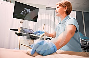 Doctor performing ultrasound procedure in modern clinic.
