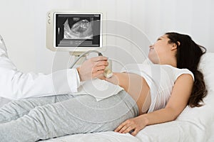 Doctor Performing Ultrasound Scan On Expecting Woman