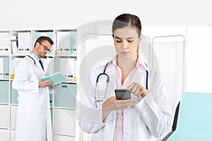 Doctor on phone, with colleague in medical office