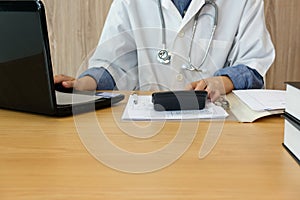 doctor physician with stethoscope calculate medical fee costs & revenue. practitioner use calculator at hospital