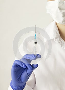 Doctor (physician,vet, MD) holds syringe (injector) with medicine (liquid) 