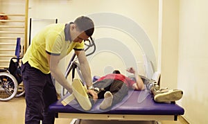 Doctor physiotherapist putting the orthosis for disabled man