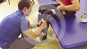 Doctor physiotherapist putting the orthosis for disabled man