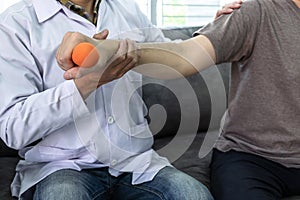 Doctor physiotherapist treating arm pain patient doing physical therapy exercises with his therapist in clinic - sport physical