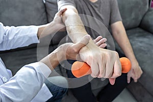 Doctor physiotherapist treating arm pain patient doing physical therapy exercises with his therapist in clinic - sport physical