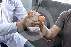 Doctor physiotherapist treating arm pain patient doing physical therapy exercises with his therapist in clinic - sport physical