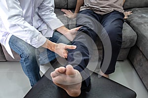 Doctor physiotherapist treating leg pain patient doing physical therapy exercises with his therapist in clinic - sport physical