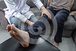 Doctor physiotherapist treating leg pain patient doing physical therapy exercises with his therapist in clinic - sport physical