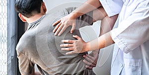 Doctor or Physiotherapist working examining treating injured back of athlete male patient, Doing the Rehabilitation therapy pain