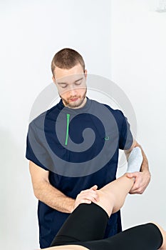 Doctor or Physiotherapist working examining treating injured leg of athlete male patient, Doing the Rehabilitation