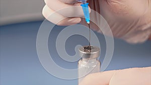 Doctor piercing the lid of the ampoule with syringe