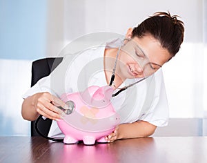 Doctor With Piggy Bank And Stethoscope