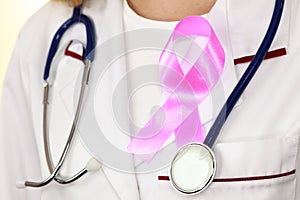 Doctor with pink cancer ribbon aids symbol on chest