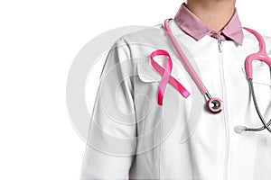 Doctor with pink ribbon and stethoscope on background, closeup. Breast cancer awareness