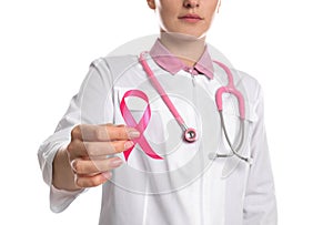 Doctor with pink ribbon and stethoscope on background, closeup. Breast cancer awareness