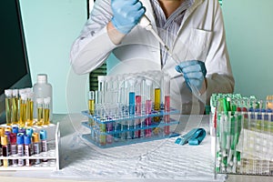 Doctor pipetting sample for study in tube