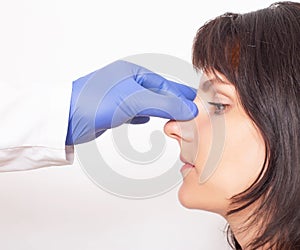 Doctor plastic surgeon prepares a caucasian girl for nose plastic surgery. Rhinoplasty photo