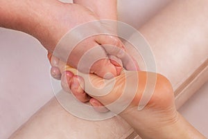 The doctor-podiatrist does an examination and massage of the patient`s foot