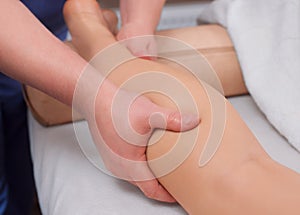 Doctor-podiatrist does an examination and massage of the patient`s legs