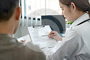 Doctor is pointing on document to explaining disease and symptoms for patient during to talking