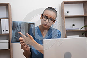 doctor pointing on x-ray film showing to patient in laptop during online tele medicine consultation