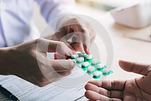 Doctor is pointing to drug tablet and introducing the properties of the painkiller to patient at office