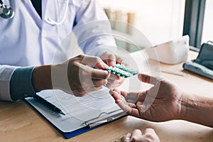 Doctor is pointing to drug tablet and introducing the properties of the painkiller to patient at office