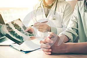 Doctor pointing to the x-ray sheet and describe a viral disease