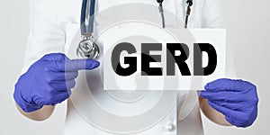 The doctor points his finger at a sign that says - GERD. GASTRO-ESOPHAGEAL REFLUX DISEASE