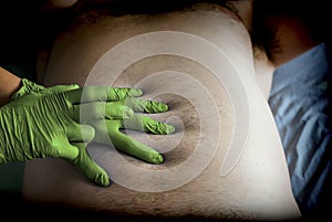 Doctor preparing abdominal palpation in a hospital, conceptual image photo