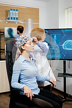 Doctor preparing brain waves scanning headset for tests