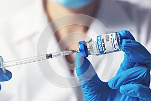Doctor preparing covid-19 vaccine dose for vaccination. closeup of syringe and vial in hands
