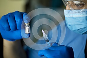 Doctor preparing injection with covid-19 vaccine at hospital