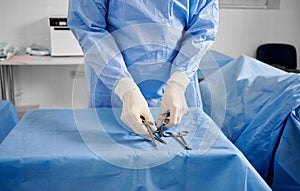 Doctor preparing instruments for plastic surgery in operating room.