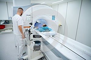 Doctor preparing man for knee magnetic resonance imaging procedure